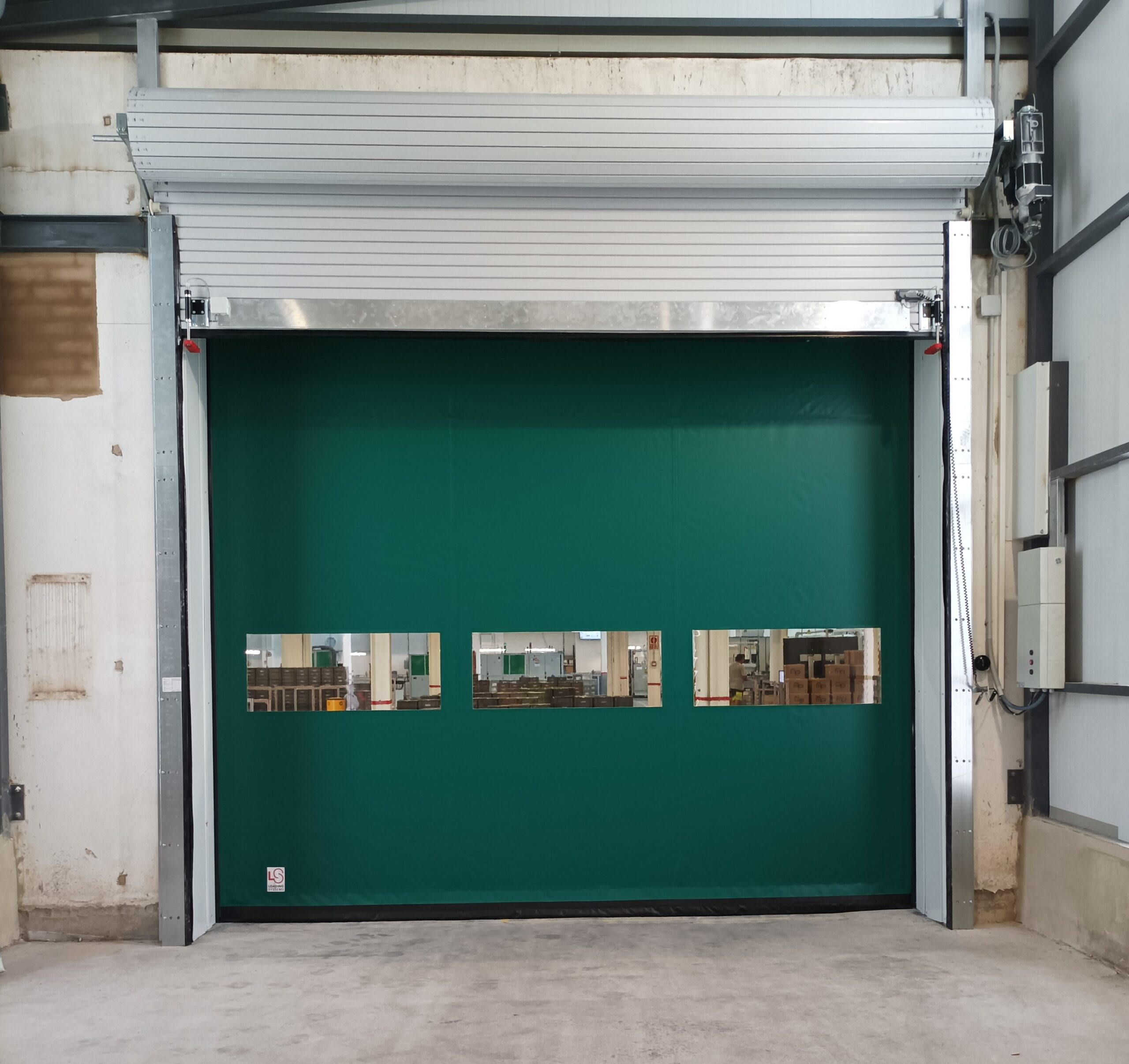Puerta enrollable EI2.60 y puerta rápida autoreparable en la infraestructura logística de una nave industrial